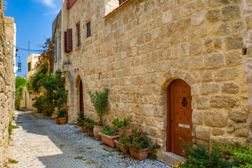 Fototapeta premium Narrow cobblestone alley with stone walls in the Rhodes Old town, Greece