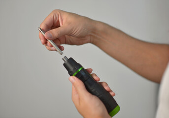 A man changing drill bit in electric screwdriver