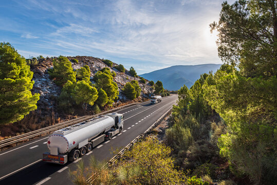 Two fuel tanker trucks passing each other on a two-way mountain road