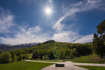 Bright sun shines over the historic Borgund Stave Church, a famous landmark in a stunning Norwegian mountain valley.