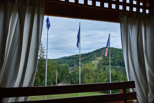 Scenic view of a mountain landscape with flags from a cozy balcony