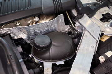 Closeup of coolant container during vehicle maintenance process, Technician topping off coolant...