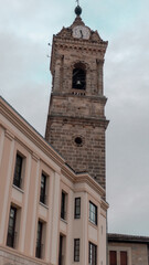 Obraz premium Historic church bell tower against cloudy sky in Vitoria-Gasteiz old town, Basque Country, Spain 