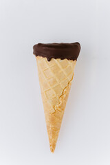 Chocolate dipped ice cream cone isolated on white background, minimal dessert concept