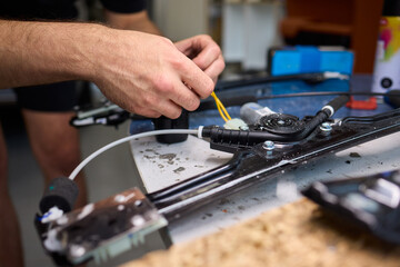 Mechanic fixing vehicle door parts, Closeup of technician repairing car interior components, Professional worker servicing vehicle door with detailed focus and tools