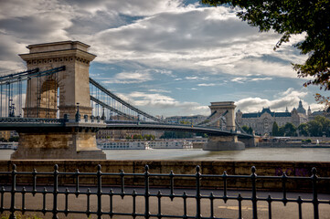 Budapest, Hungary - July 27, 2025: Detailed views of the Sz&eacute;chenyi Chain Bridge with its steel structure, rivets, and ornate lamps spanning the Danube River
