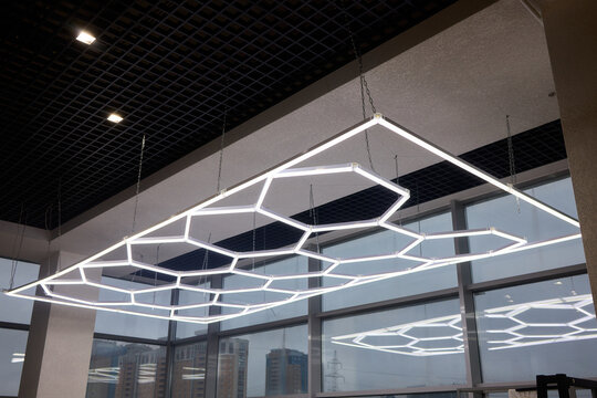 Sleek hexagonal fixtures enhancing modern office and retail environments, Innovative ceiling lighting with geometric shapes to elevate commercial interior aesthetics