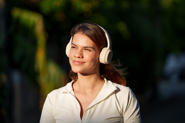Happy young woman enjoying morning sunlight during outdoor exercise in nature	