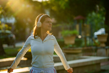Happy young woman enjoying morning sunlight during outdoor exercise in nature