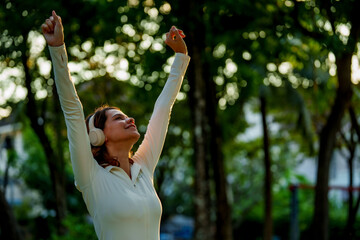 Happy young woman enjoying morning sunlight during outdoor exercise in nature