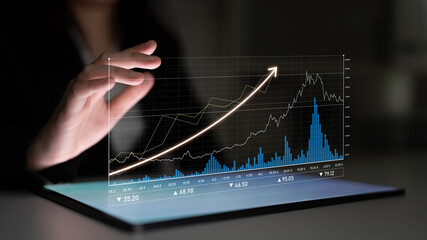 A futuristic scene showcasing a hand interacting with a transparent digital screen, displaying dynamic graphs and financial trends in a modern workspace setting. Scalp