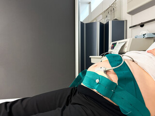 Pregnant woman undergoing cardiotocography monitoring in hospital