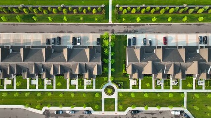 Aerial top-down view of modern condo townhomes with parking and landscaped sidewalks—clean geometry and green space ideal for real estate and community planning visuals.