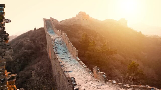 Aerial shot of the Great Wall of China at sunset on a hazy day.