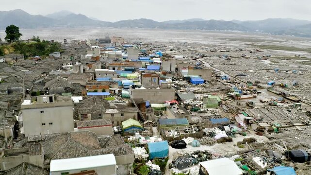 Aerial shot of small fishing town on the coast of Xiapu County in China. The bamboo poles are for drying seaweed.