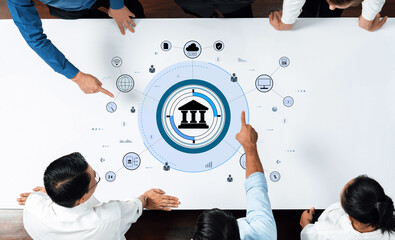 A diverse team engages in financial data analysis, utilizing a digital interface rich in banking symbols, presenting innovative solutions and strategies for modern business environments. Trope
