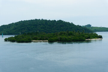 Fototapeta premium A view in the middle of the sea showing an uninhabited island in Indonesian waters, on the border of Sumatra.