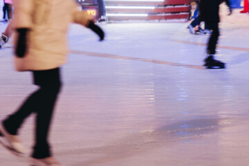 Ice skating on the ice rink arena with people, skating rink surface, ice skating in winter city, winter activities, holiday christmas time, with new year decoration and illumination, ice skates boots
