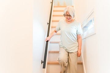 Senior woman suffering from knee pain going down the stairs at home  © buritora
