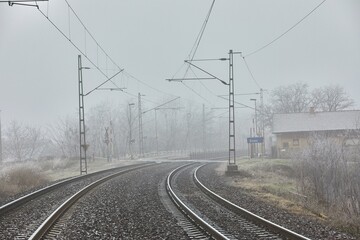 Double track railway main line rails in winter frost snow and fog
