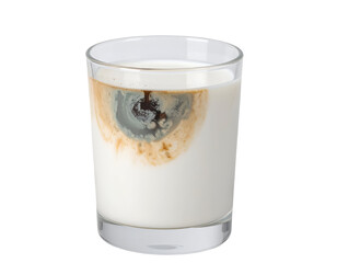 A glass of milk with a coffee stain or spill creating an abstract pattern on the surface