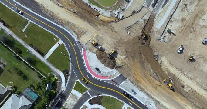 Driving traffic cars at roundabout intersection under construction. Building traffic circle on American road with moving cars.