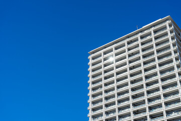Fototapeta premium Looking up at the buildings of Yokohama under the blue sky.