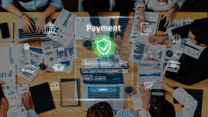 A team collaborates over financial reports and laptops, focusing on payment processing in a productive workspace filled with modern technologies and data analysis tools. Raster