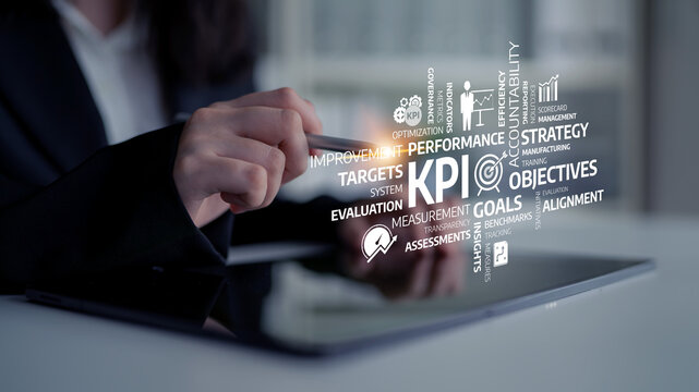 A business professional analyzes key performance indicators on a tablet in an office, illustrating strategic planning and goal evaluation for optimal performance. Tessel - Powered by Adobe