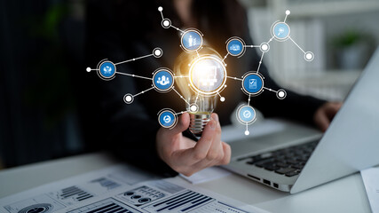 A visual representation of innovative business ideas with a light bulb and networking connections symbolizing creativity and technology in a modern office setting. Tessel