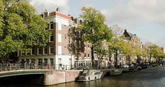 Exploring the picturesque canals of Amsterdam with charming architecture and vibrant tree-lined streets on a sunny afternoon