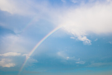 Beautiful summer time blue sky and white cloud between rainbow. Nature background with copy space.