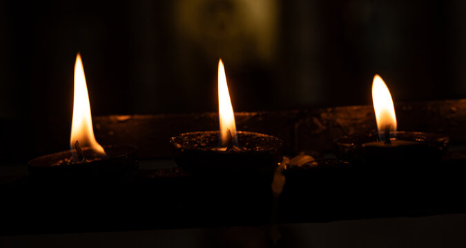 Tres velas encendidas alineadas creando una atm&oacute;sfera c&aacute;lida y contemplativa