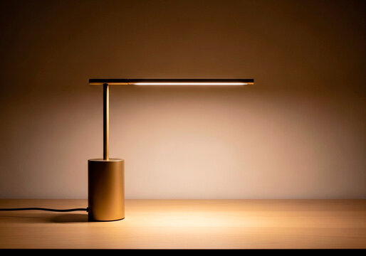 Contemporary interior decor: gold desk lamp on wooden table, modern lighting concept, warm glow, copy space available