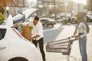 African arabian couple pack grocery in a car