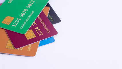 Four vibrantly colored credit cards, including black, white, red, and orange, diagonally arranged with blank white copy space, symbolizing diverse financial choices, payment options, or banking servic