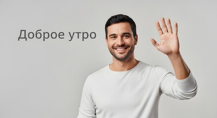 A cheerful man with a welcoming smile and an outstretched hand greets the viewer with a friendly wave against a plain background