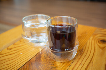 a glass of yemeni coffee and water on the wooden table in the cafe in seoul