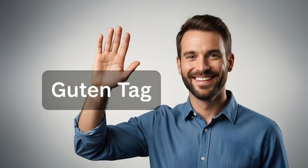 A smiling man with a beard and short hair waving his hand in a friendly gesture against a plain gray background
