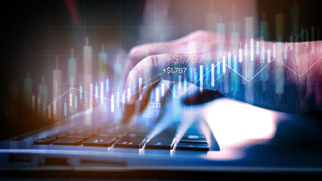 Close-up of businessman's hands typing on a laptop, analyzing financial stock market charts, data, and graphs for investment and trading.