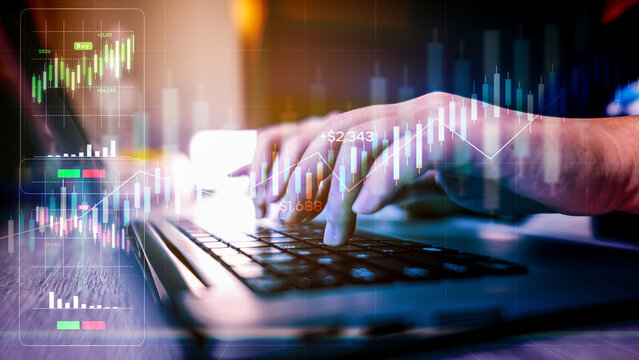 Close-up of businessman's hands typing on a laptop, analyzing financial stock market charts, data, and graphs for investment and trading.