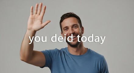 A smiling young man with a beard and short hair waving his hand in a friendly gesture against a neutral background
