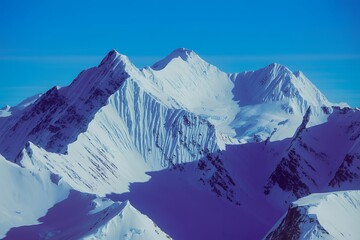 Fototapeta premium Majestic snow-capped mountain range under a clear blue sky mountains winter