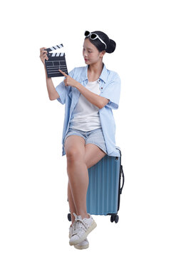 The Aspiring Filmmaker: A young woman, radiating enthusiasm, holds a clapperboard in hand, embodying a blend of film production with the thrill of travel, ready to direct her cinematic journey.