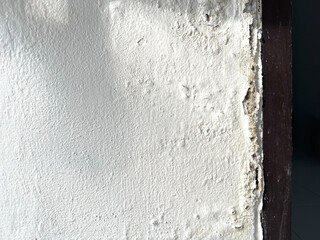 Shadow of broken washbasin drain pipe on damped, musty old painted wall with sunlight. Closeup textured exterior toilet wall in room at dhamma retreat center, Saraburi, Thailand. 25 OCT 2025. A.M.