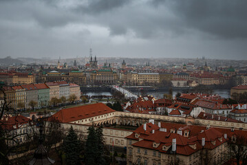 Obraz premium Prague city and river appear mysterious beneath foggy, darkened skies.