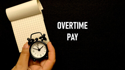 Alarm Clock and Notebook with "Overtime Pay" Concept on Black Background for Business Finance and Work-Life Balance
