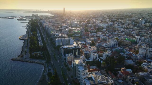 Aerial panoramic view of Limassol, Cyprus, highlighting the modern skyline, residential areas, and green spaces. The image captures the vibrant city life, urban development.