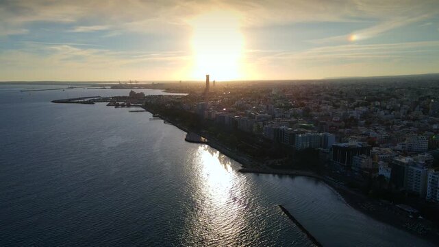 Aerial panoramic view of Limassol, Cyprus, highlighting the modern skyline, residential areas, and green spaces. The image captures the vibrant city life, urban development.