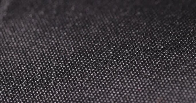 dense black synthetic fabric for bags, black fabric made of black threads resistant to damage, close up
